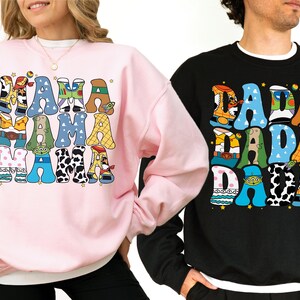 Two people wearing sweatshirts with colorful text and graphics on them.