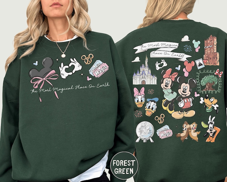 A woman wearing a green sweatshirt with various Disney characters and Disney-themed graphics printed on it.