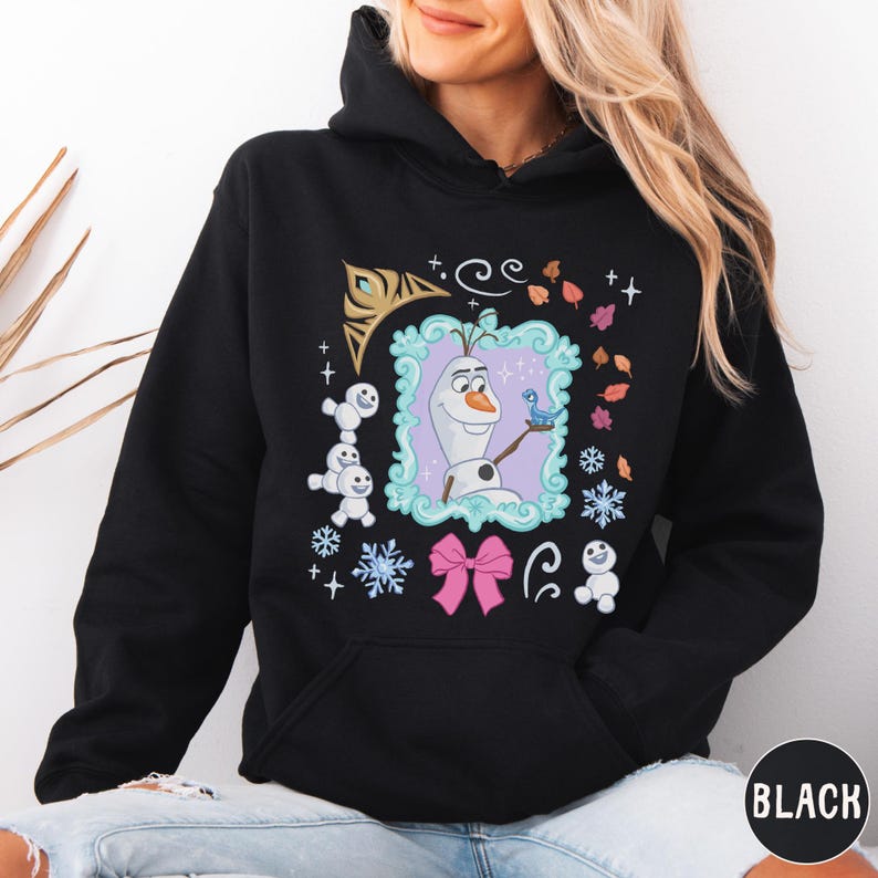 A woman wearing a black hoodie with a colorful graphic design featuring characters from the Disney movie Frozen.