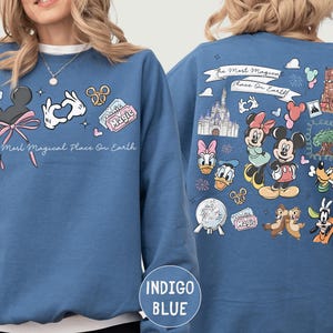 A woman wearing a blue sweatshirt with various Disney characters and Disney-themed graphics printed on it.
