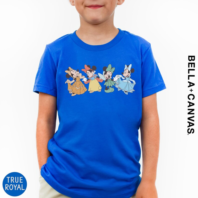 A young boy wearing a blue t-shirt with a line of four Disney Minnie Mouse characters.
