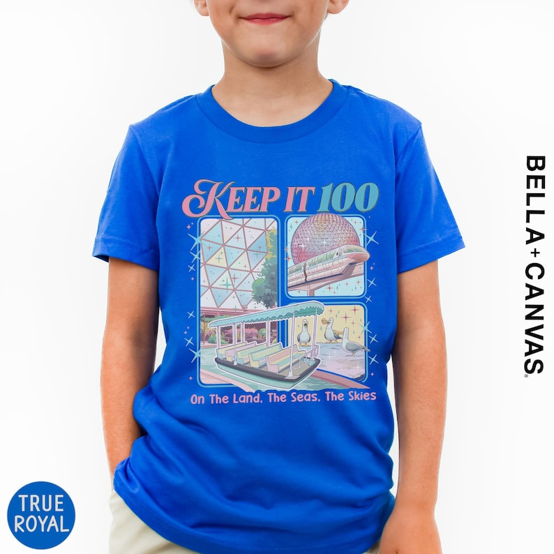 A young boy wearing a blue t-shirt with a graphic design featuring a collage of images related to the Disney theme park, specifically the Space Needle.