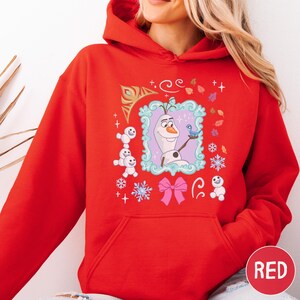 A red hoodie with a graphic of Olaf, the main character from the Disney movie Frozen, surrounded by various snowflakes and other winter-themed elements.