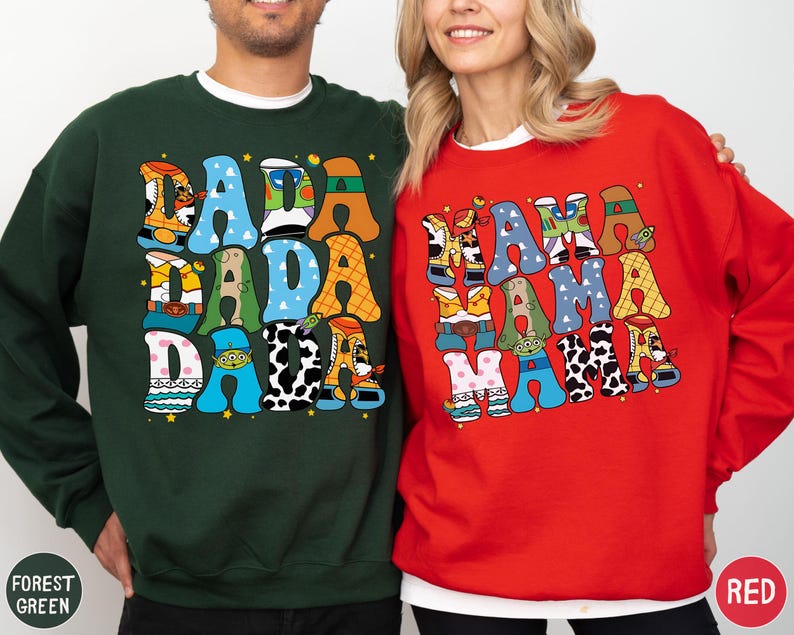 A man and a woman are standing next to each other, both wearing colorful sweatshirts with large, colorful text.
