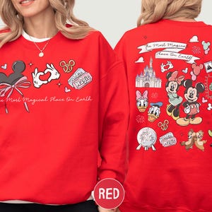 A red sweatshirt with various Disney characters and Disney-themed graphics printed on it.