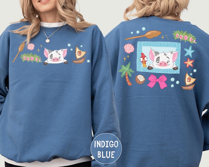 A woman wearing a blue sweatshirt with a pig design and various other colorful elements on the back.