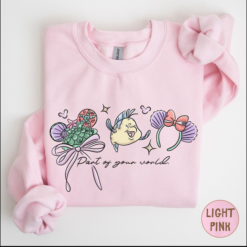 A pink sweatshirt with a cartoon character and text printed on it.