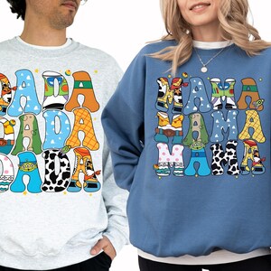 two people wearing sweatshirts with a colorful, cartoon-style design.