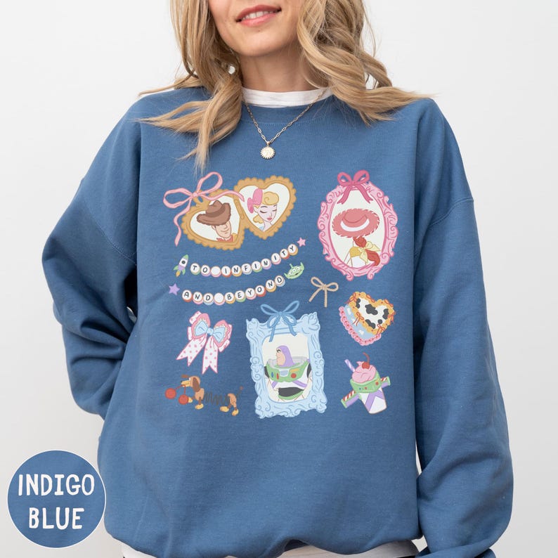 A woman wearing a blue sweatshirt with various cartoon-style illustrations and text on it.