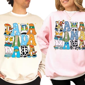 two people wearing sweatshirts with colorful text and graphics.