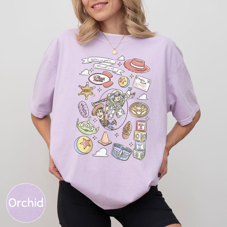 A woman wearing a purple t-shirt with various cartoon-style icons and characters printed on it.