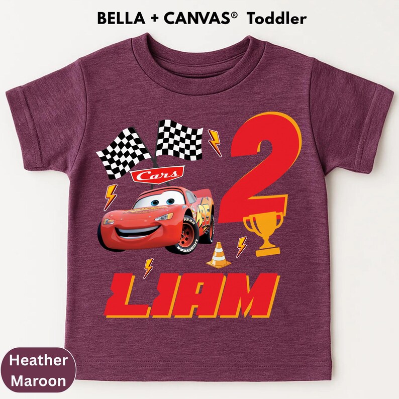 A purple t-shirt with a design featuring the character Lightning McQueen from the Cars movie, along with a number 2 and the text "Liam".