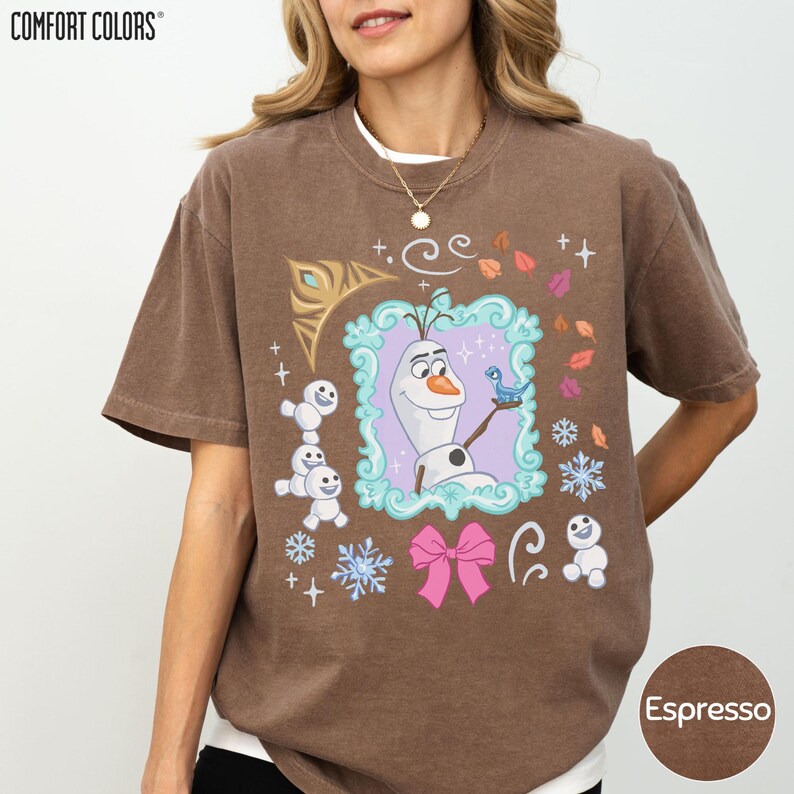 A woman wearing a brown t-shirt with a graphic design featuring characters from the Disney movie Frozen.