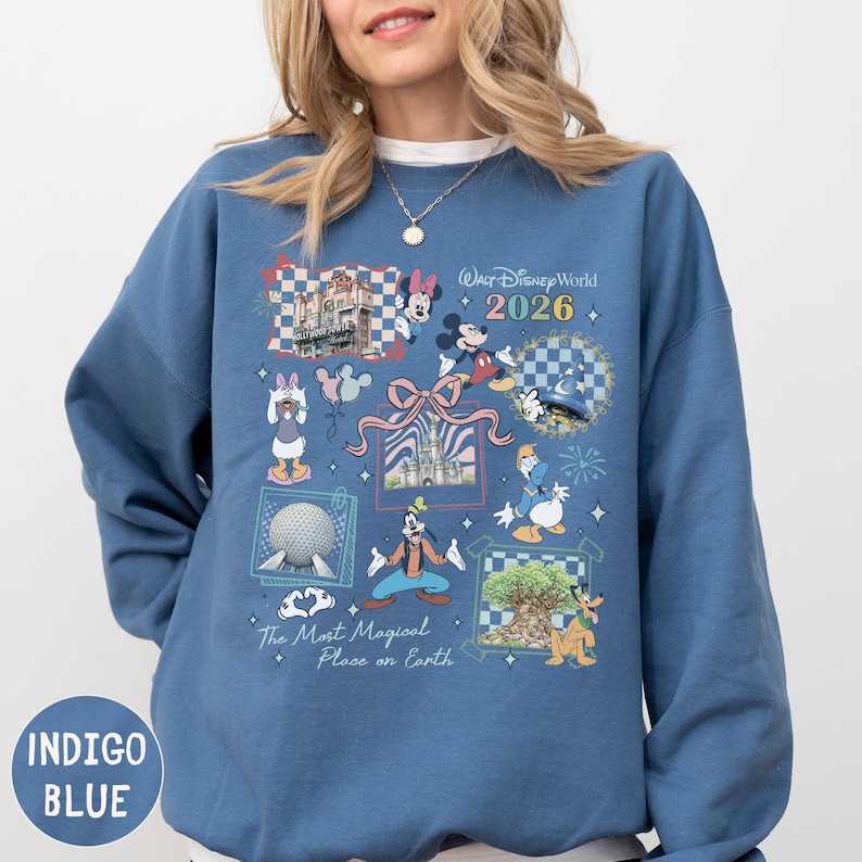 A woman wearing a blue sweatshirt with various Disney-themed illustrations and text.