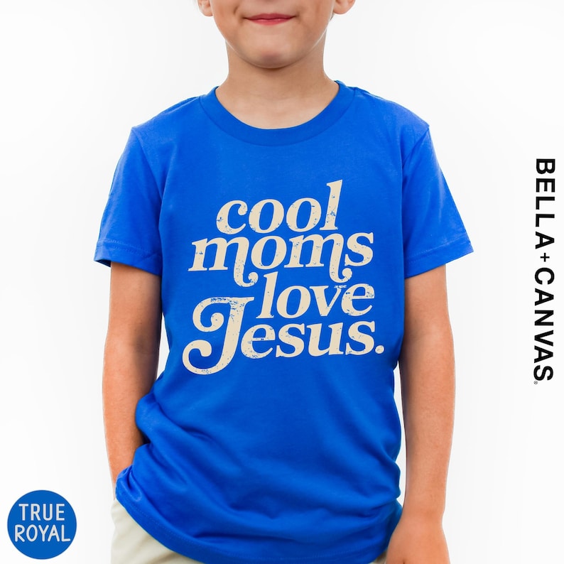 A young boy wearing a blue t-shirt with the text "cool moms love Jesus" printed on it.