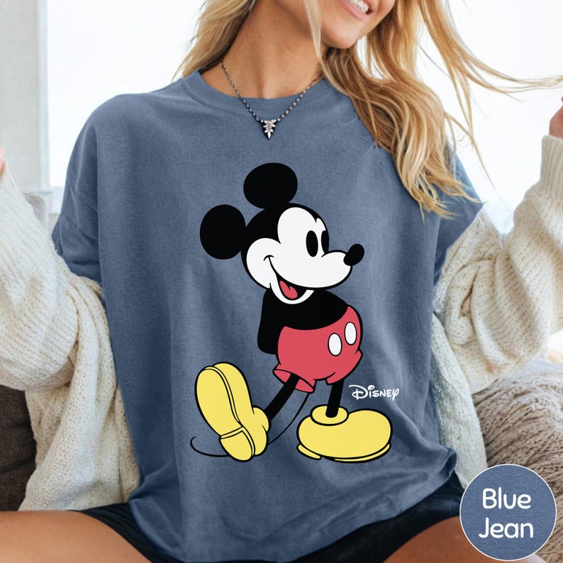 A woman wearing a blue t-shirt with a cartoon image of Mickey Mouse printed on it.