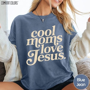 A woman wearing a blue t-shirt with the text "cool moms love Jesus" printed on it.