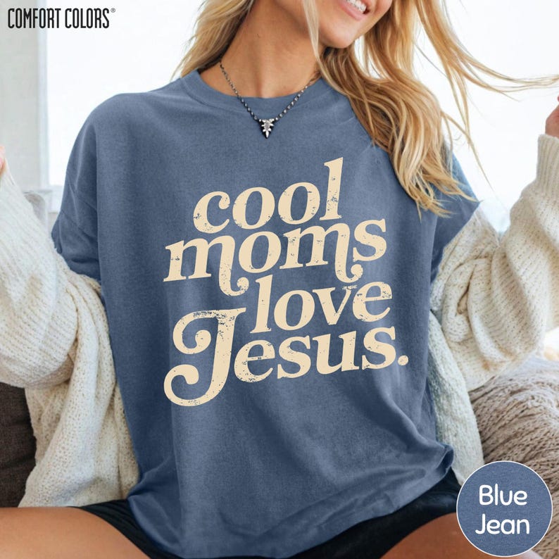 A woman wearing a blue t-shirt with the text "cool moms love Jesus" printed on it.