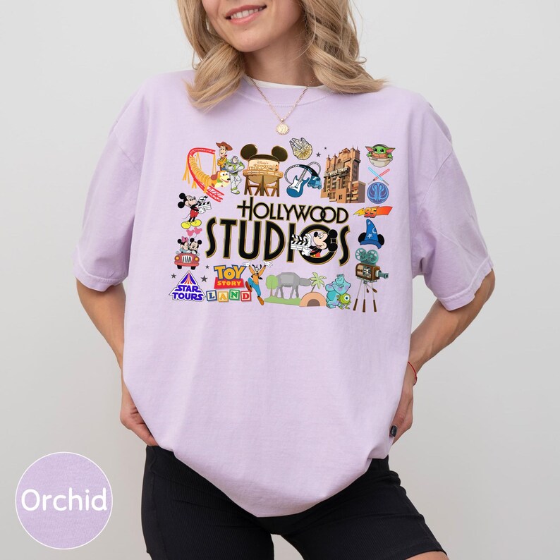 A woman wearing a pink t-shirt with various Disney and Hollywood-themed graphics and text, including Mickey Mouse, the Star Wars logo, and other iconic symbols.