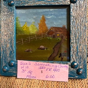 May include: A framed painting of a rustic cabin in a wooded setting. The painting is 3 inches square and is framed in a blue wood frame. The price tag reads "Sue's Something Crafty #FR 400 $6.00".