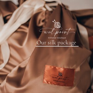 May include: A brown silk pouch with a white logo that says "wool.point knitwear boutique" and the text "Our silk package".