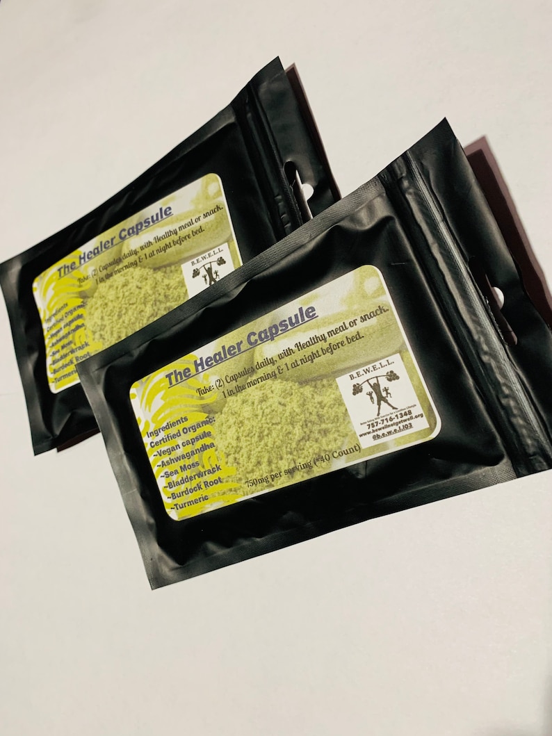May include: Two black resealable pouches with green and yellow labels. The label reads "The Healer Capsule" and lists ingredients including Ashwagandha, Sea Moss, Bladderwrack, Burdock Root, and Turmeric. The label also states "Take: (2) Capsules daily, with Healthy meal or snack. 1 in the morning & 1 at night before bed." and "750mg per serving (*40 Count)".