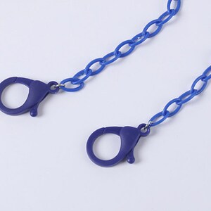 May include: A blue plastic chain with two blue plastic clasps. The chain is approximately 20 inches long.