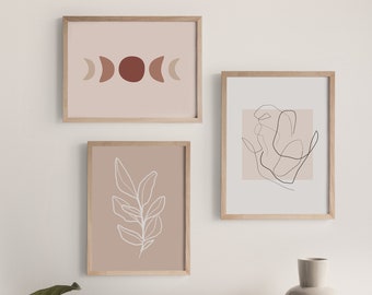 Könnte beinhalten: Drei gerahmte Kunstdrucke mit minimalistischen Designs. Der obere Druck zeigt eine Mondphasengrafik in Braun- und Beigetönen. Der mittlere Druck hat eine weiße Blattoberfläche auf beigem Hintergrund. Der dritte Druck hat eine schwarze Strichzeichnung auf beigem Hintergrund.