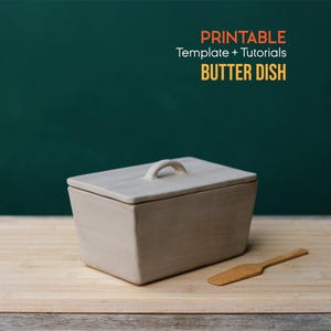 May include: A rectangular, light-colored butter dish with a lid and handle, alongside a small wooden butter knife. The words "PRINTABLE Template + Tutorials BUTTER DISH" are in the upper right corner. The items rest on a wooden cutting board.