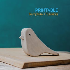 Könnte beinhalten: Eine hellgraue Keramik-Vogelfigur mit kleinem Schnabel und rundem Augendetail. Der Vogel steht auf einer hellbraunen Holzoberfläche vor einem türkisfarbenen Hintergrund. Der Text oben lautet "PRINTABLE Template + Tutorials".