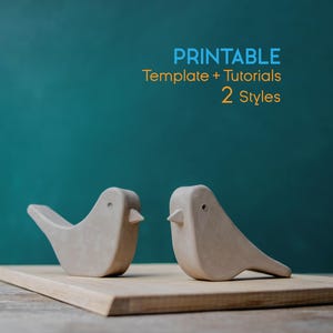 以下が含まれることがあります： 2つの薄い灰色の鳥の彫刻が、ターコイズ色の背景に対して木の板の上に展示されています。鳥は、小さなくちばしを持つ、シンプルで丸みを帯びた形をしています。上部のテキストには「PRINTABLE Template + Tutorials 2 Styles」と書かれています。