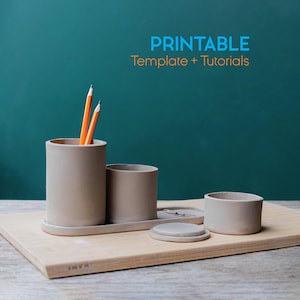May include: A set of beige ceramic desk organizers on a wooden tray. The set includes a pencil holder with pencils, a small cup, a container with a lid, and a small tray. The text "PRINTABLE Template + Tutorials" is in the background.
