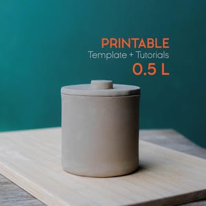 May include: A cylindrical, light brown ceramic container with a lid and a small knob on top. The container is labeled "0.5 L" and sits on a light-colored wooden board against a teal background. The text "PRINTABLE Template + Tutorials" is also visible.