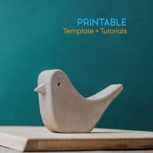 May include: A light beige ceramic bird figurine with a small beak and a curved tail, set on a wooden surface. The background is a teal color. Text at the top reads "PRINTABLE Template + Tutorials".