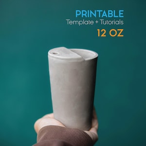 May include: A gray, cylindrical tumbler with a lid, held against a teal background. The text "PRINTABLE Template + Tutorials" and "12 OZ" are displayed in blue and orange. The tumbler is approximately 9 cm tall.