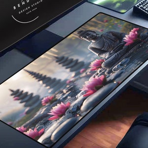 Puede incluir: Una alfombrilla de ratón negra y gris con una imagen serena de una estatua de Buda rodeada de flores de loto rosas y estructuras de piedra. El fondo presenta un paisaje brumoso y etéreo.