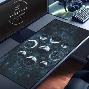 May include: A black and white desk mat with a design of moons and stars. The design is intricate and detailed, with a geometric pattern. The mat is made of a durable material and is perfect for protecting your desk from scratches and spills.