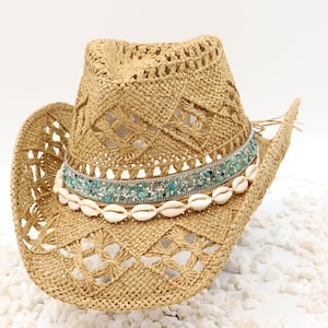 May include: A straw cowboy hat with a turquoise and silver beaded band and a row of white seashells.