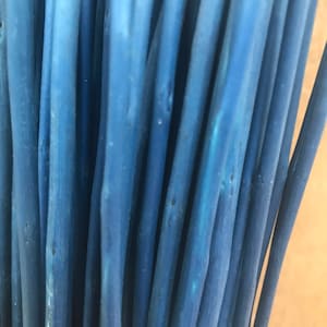 May include: A bunch of blue painted wooden sticks, arranged vertically, with a close-up view of the textured surface.
