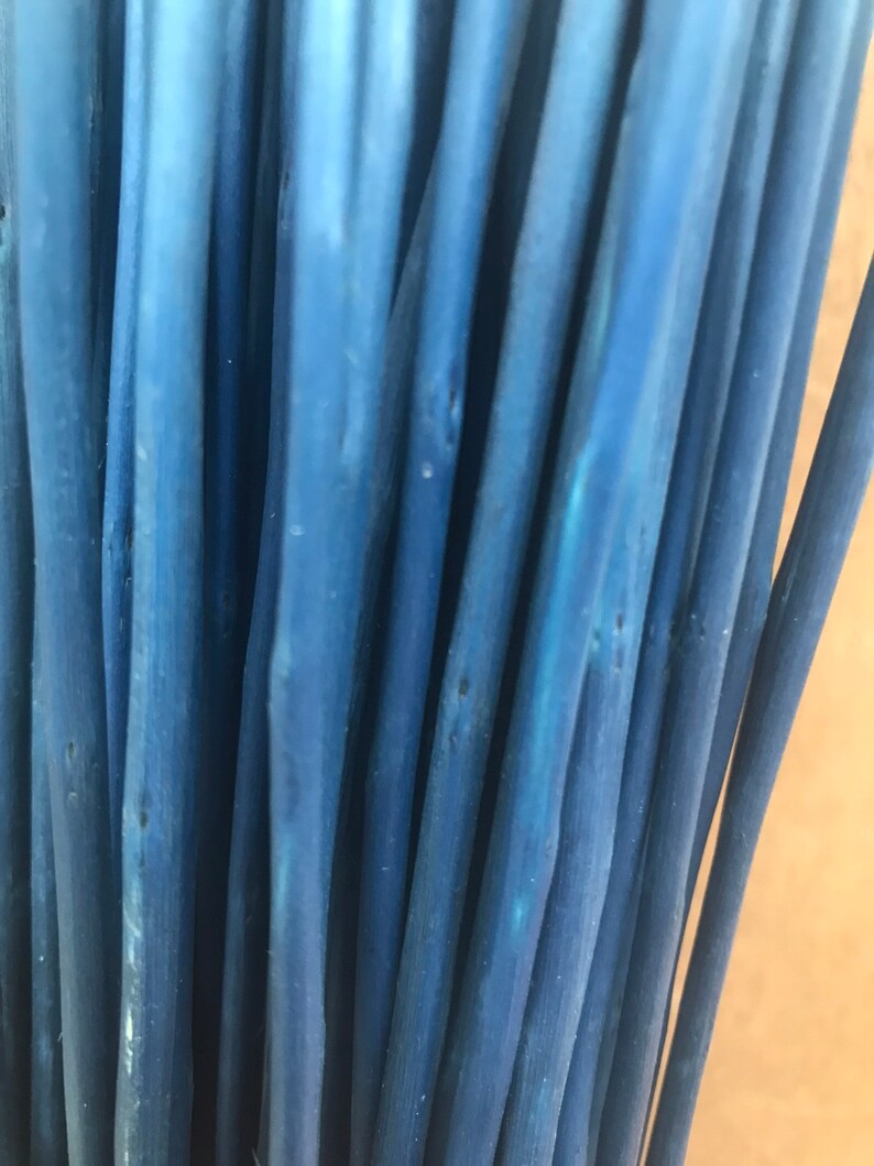 May include: A bunch of blue painted wooden sticks, arranged vertically, with a close-up view of the textured surface.