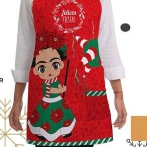 Puede incluir: Delantal rojo de Navidad con borde de rayas verdes y blancas. El delantal presenta una ilustraci&oacute;n de dibujos animados de Frida Kahlo con un vestido verde y una corona de flores rojas. El texto "felices fiestas" est&aacute; escrito en una corona sobre su cabeza.