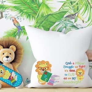 Könnte beinhalten: Ein weißes Kissen mit gesticktem Text, der lautet "Grab a Pillow Snuggle up tight it's time to READ as we say Goodnight". Das Kissen zeigt einen Löwen, der ein Buch mit den Buchstaben "A B C" darauf hält. Auf dem Kissen befindet sich auch ein kleinerer Löwe mit einem Buch.