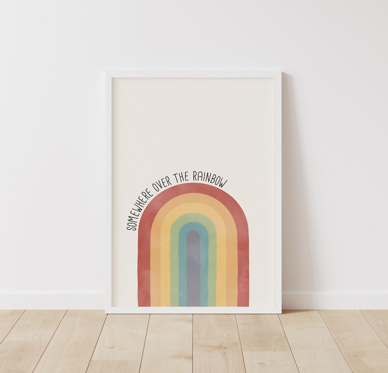 May include: A white framed print with a rainbow design and the text "Somewhere over the rainbow".