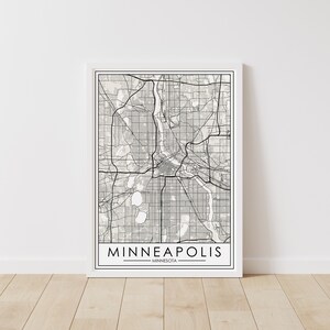 May include: A black and white minimalist map print of Minneapolis, Minnesota. The print features a detailed street map of the city with a white background and black lines.