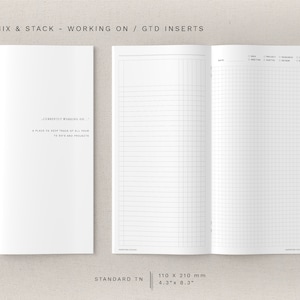 Può includere: Una doppia pagina bianca di un quaderno di dimensioni standard. La pagina sinistra è una pagina bianca con il testo "Currently working on... A place to keep track of all your to do's and projects." La pagina destra è una pagina a griglia con il testo "Date, Project, Research, Up, Meeting, Notes, Next, Notes". Il quaderno misura 110 mm per 210 mm.