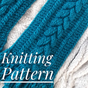 May include: A teal blue knitted scarf with a cable knit pattern. The scarf is folded in half and laid on a white fuzzy surface. The text "Knitting Pattern" is written in white on the scarf.