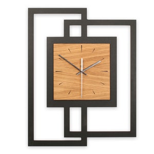 Könnte beinhalten: Eine schwarze quadratische Wanduhr mit einem Holzfarbton und schwarzen Zeigern. Die Uhr hat ein modernes Design mit überlappenden Quadraten.
