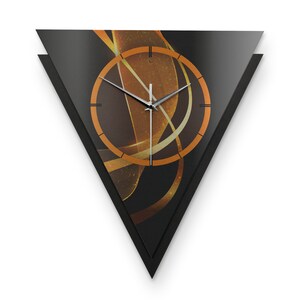 Könnte beinhalten: Eine schwarze dreieckige Uhr mit einem abstrakten Design in Gold und Orange. Das Zifferblatt der Uhr hat schwarze römische Ziffern und silberne Zeiger.