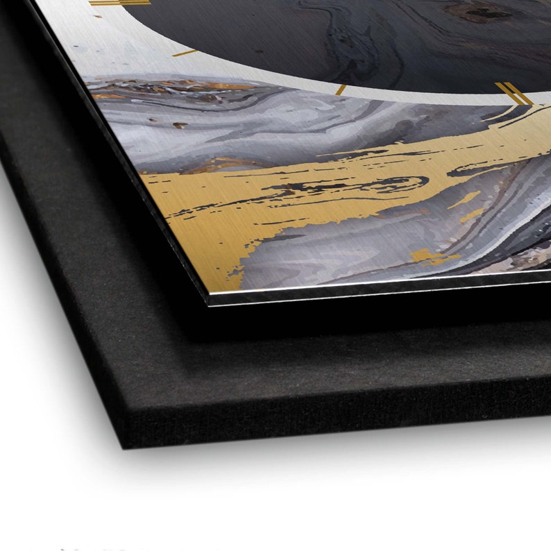 May include: A close-up of a black and gold abstract wall art print with a black circle in the upper left corner. The print is mounted on a black foam board.