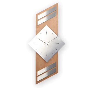 Könnte beinhalten: Eine moderne Wanduhr mit Holzsockel und silbernem, rautenförmigem Zifferblatt. Die Uhr hat silberne Akzente und ein minimalistisches Design. Der Holzsockel ist rechteckig mit abgeschrägten Seiten. Die Zeiger sind silber.